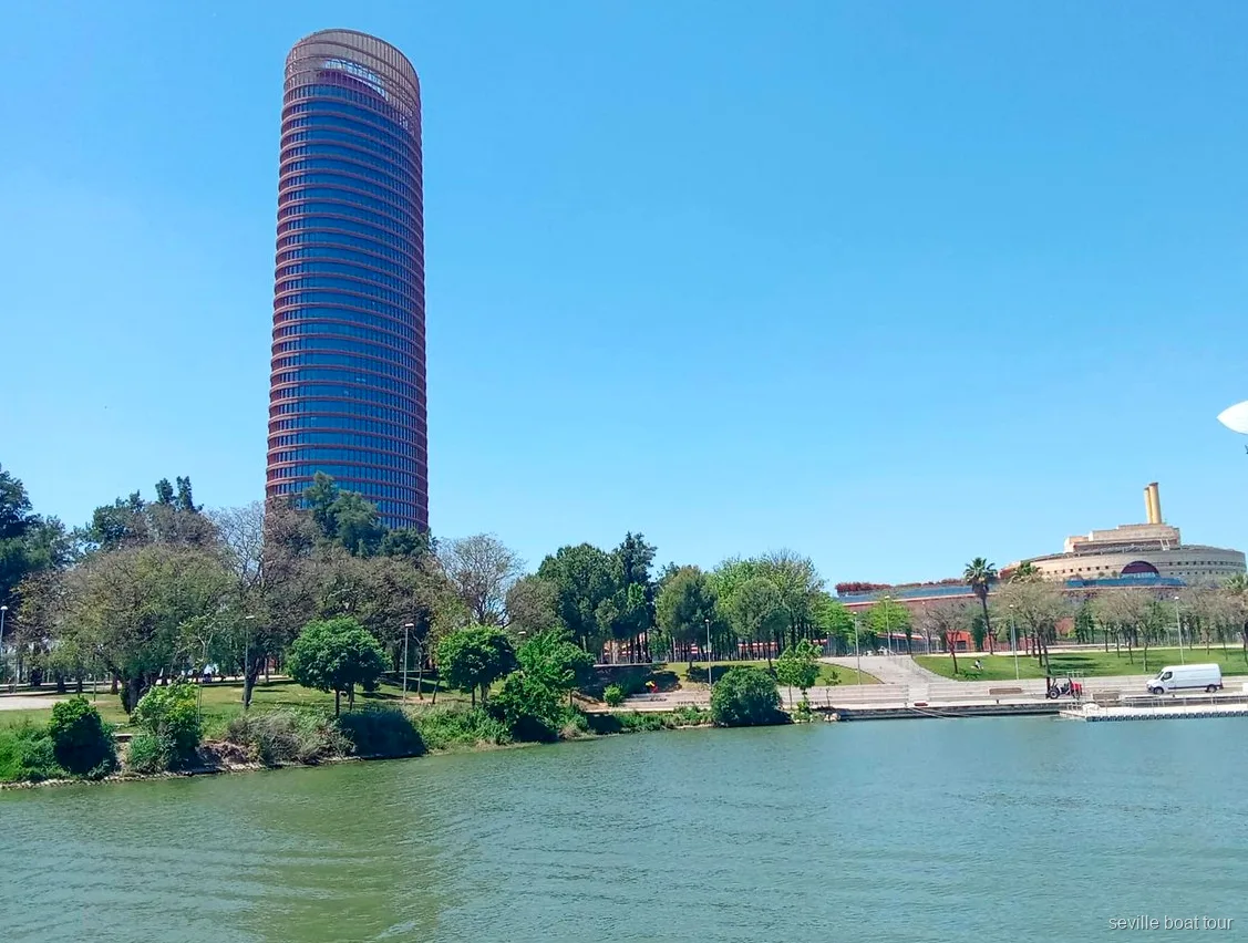 Torre Sevilla e la riva verde della Cartuja vista da un giro in barca a Siviglia sul Guadalquivir