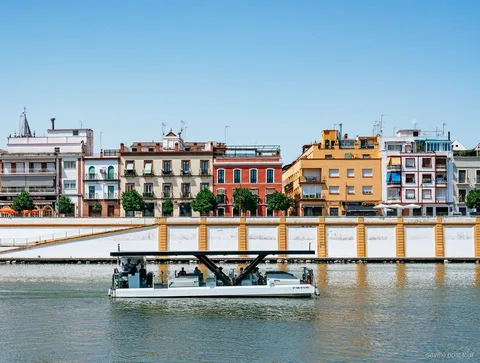 Passeggeri sulla crociera ecologica del Guadalquivir che ammirano lo skyline di Siviglia