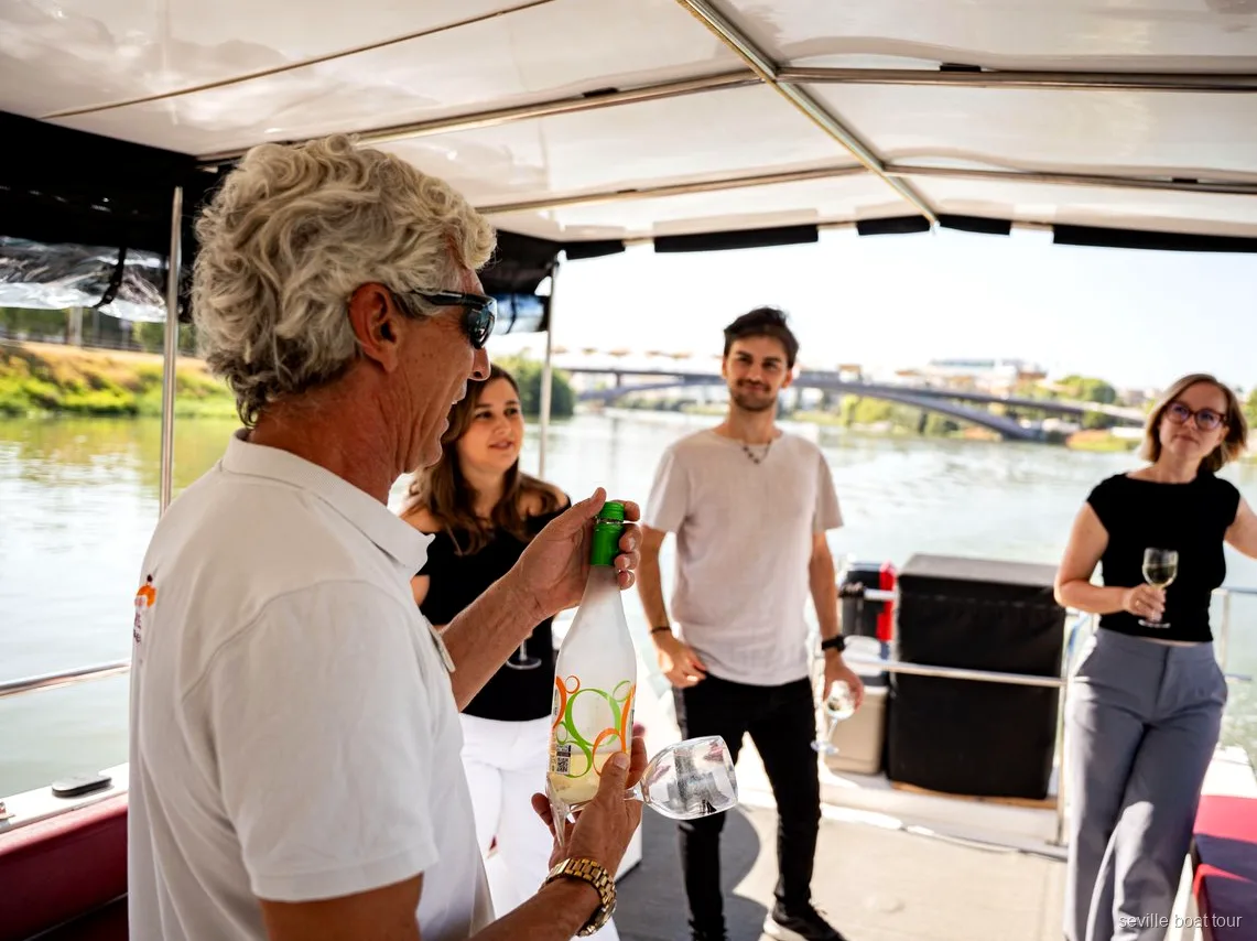 Hôte servant du vin aux passagers sous l'auvent d'une balade en bateau à Séville