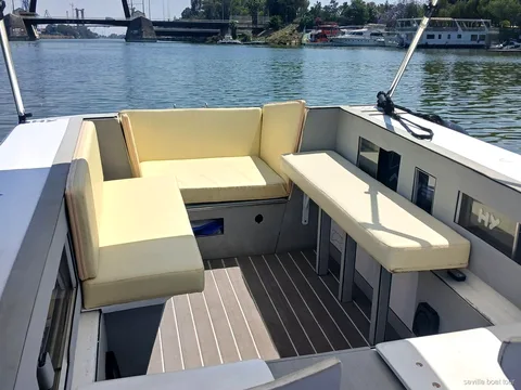 Capitano alla guida della barca elettrica privata sul fiume Guadalquivir
