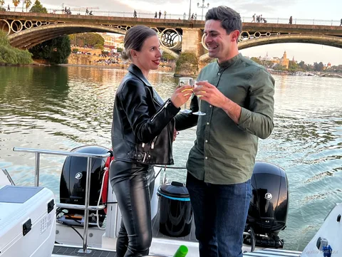 Pareja disfrutando de champán en el Paseo en Yate Romántico de Sevilla